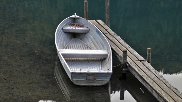 an empty row boat by the dock