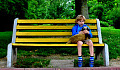 yound boy sitting on a bench holding a pet